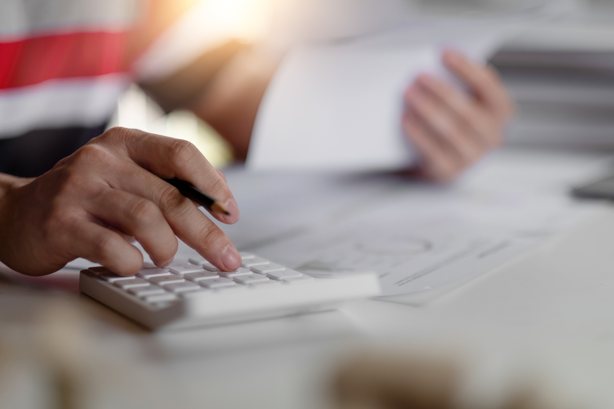 Close up man bookkeeping bills and payments with calculator at home.